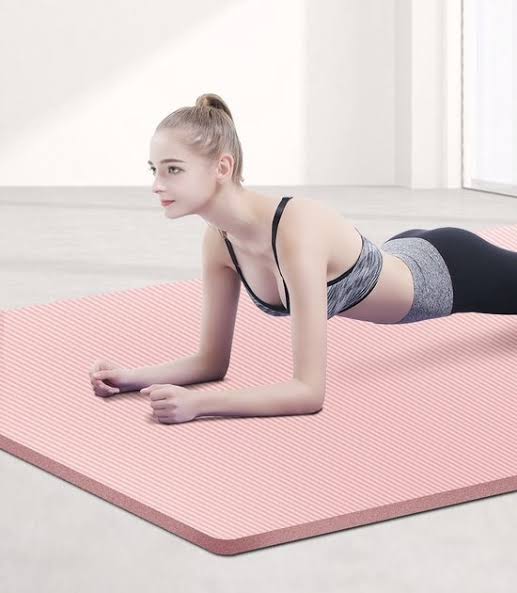 femme sur les coude sur un tapis fait exercice de la planche