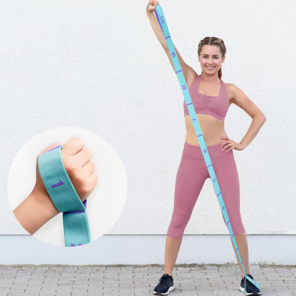 Femme debout avec un elastique dans le pied et l’autre dans la main fait un étirement de bras 